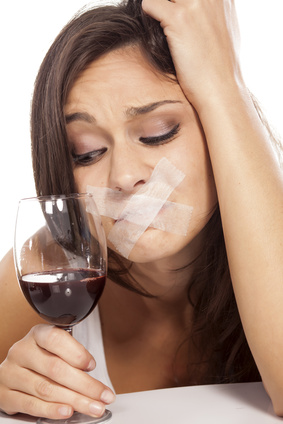 girl with adhesive tape over mouth looking at a glass of wine